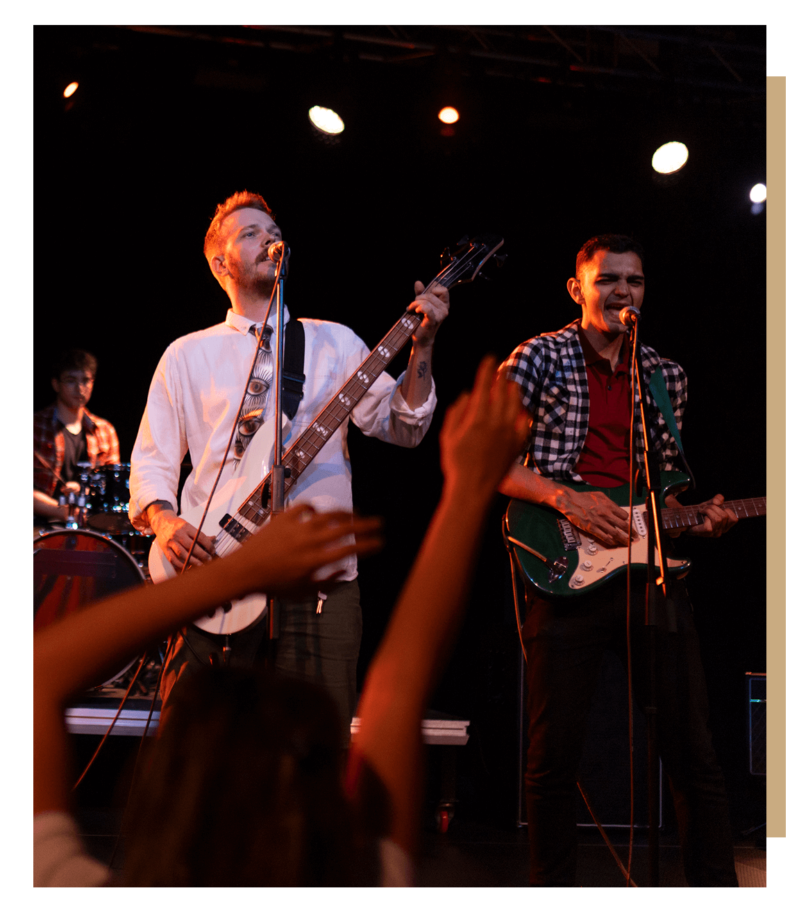 Band performing live on stage with enthusiastic audience.
