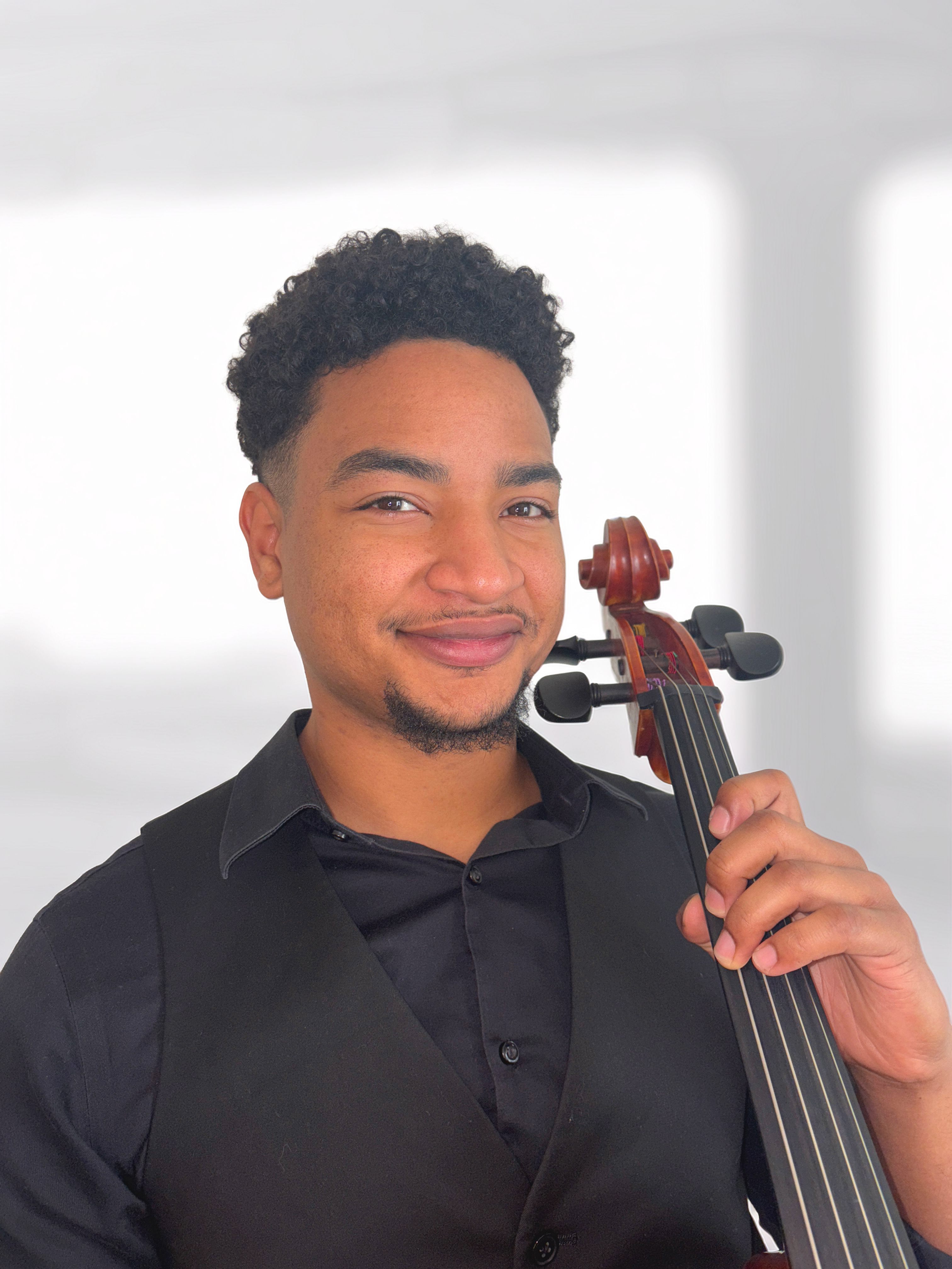 Smiling man holding a cello with a white background.